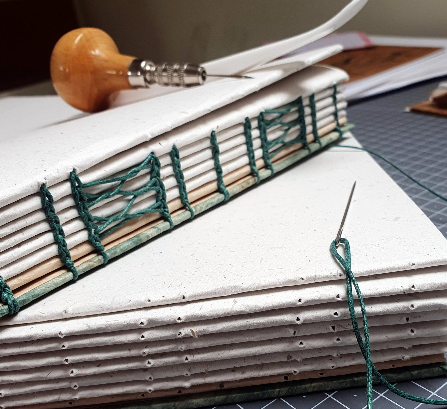 A handmade custom journal in the process of being sewn