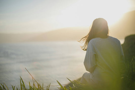 a figure sitting on an edge contemplating the ocean in a pensive mood at the beginning of the year