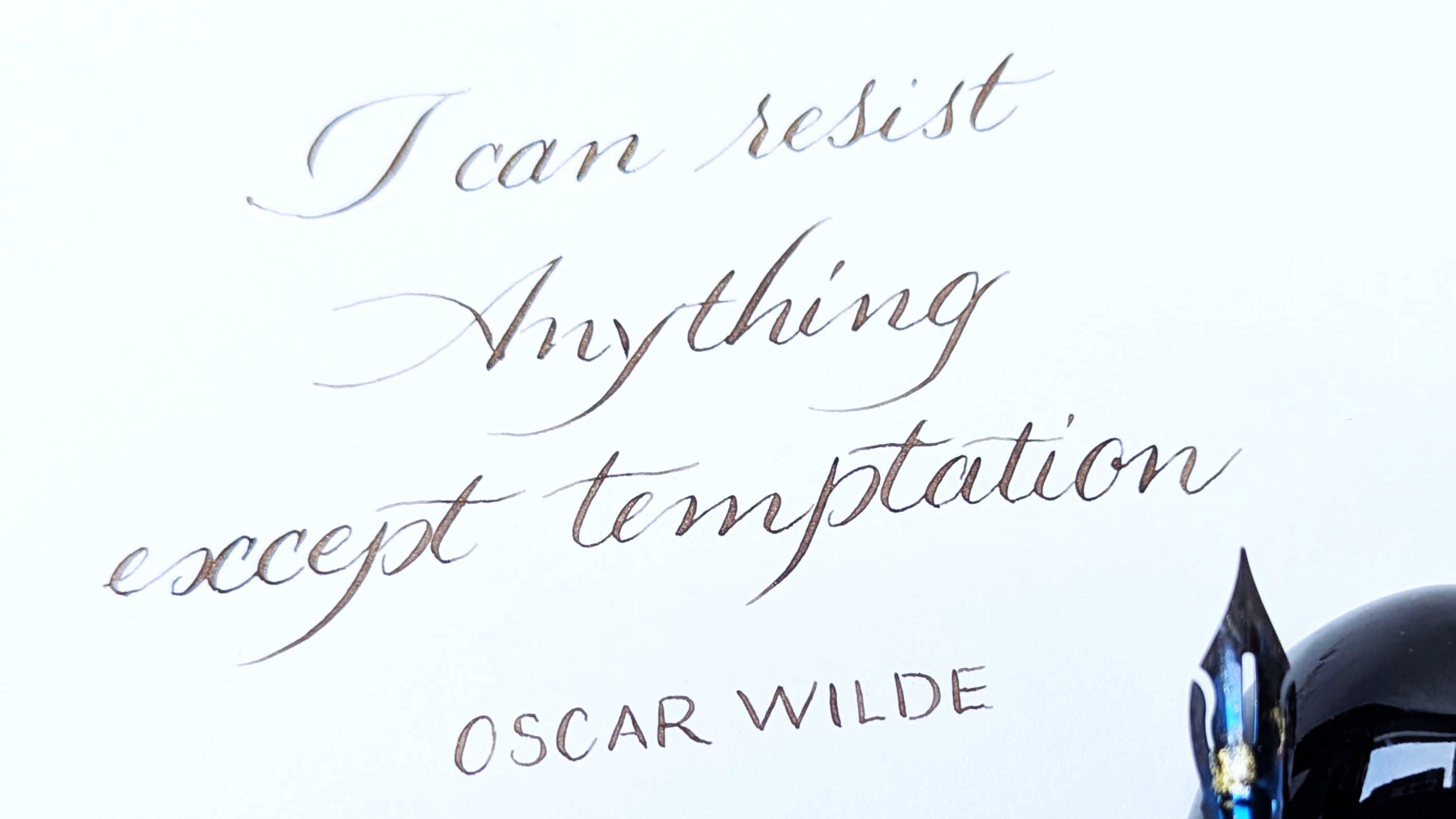 Hand written calligraphy hand: copperplate - Text 'I can resist Anything except temptation' by Oscar Wilde on a white background with a black helmet.