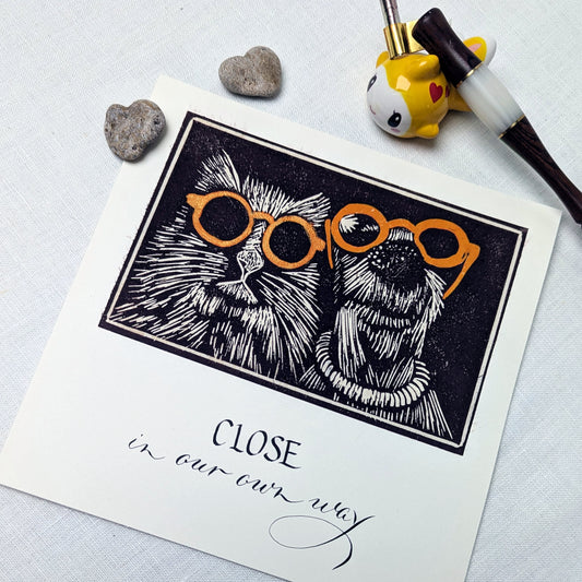 Some bonds don’t need fuss or fanfare. They’re simply… close, in their own way.

This handmade card celebrates togetherness with a soft sense of humour — perfect for couples, kindred spirits, long-term companions, or anyone who understands that closeness comes in many forms. The lino print illustration is hand-pulled, giving each card subtle variations and character, while the text is written individually using a traditional dip pen.