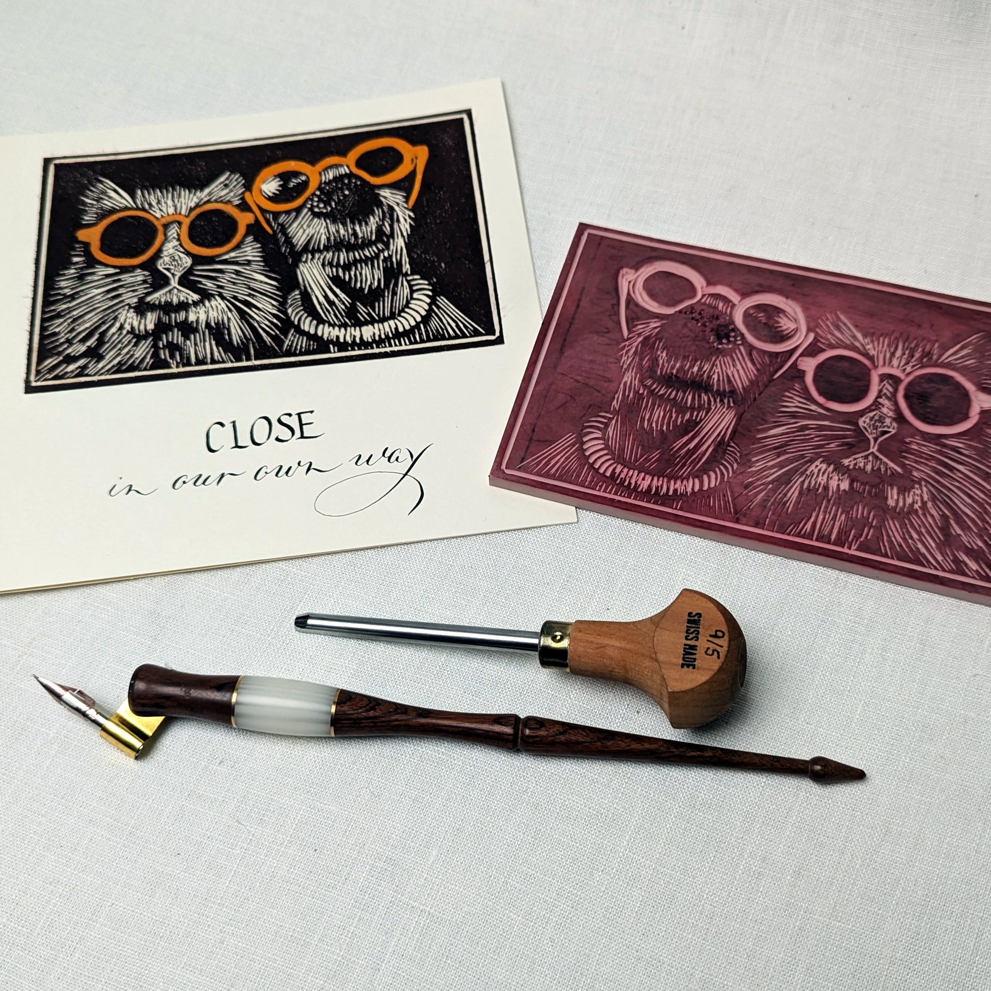 Ink pen, ink cartridge, and greeting cards with cat illustrations on a textured surface