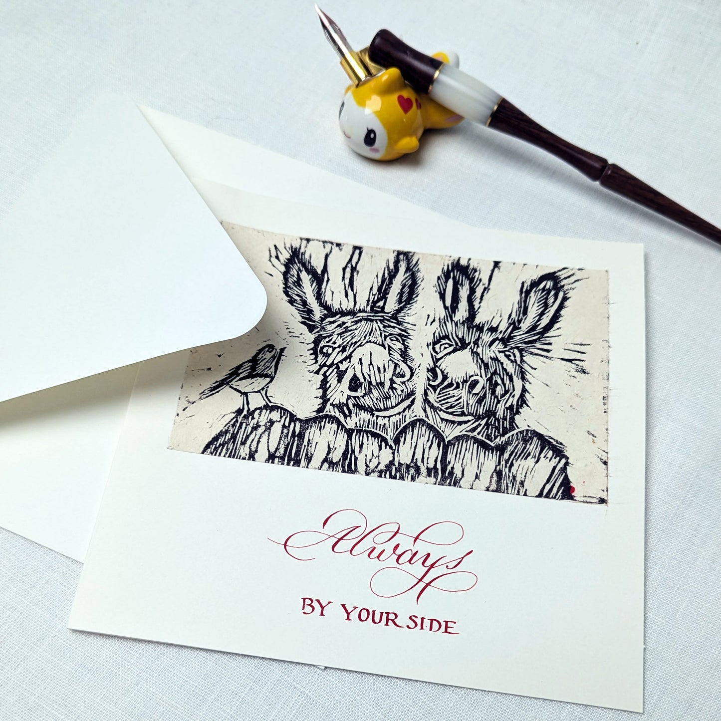 Greeting card with black and white illustration of two animals and red text on a white background