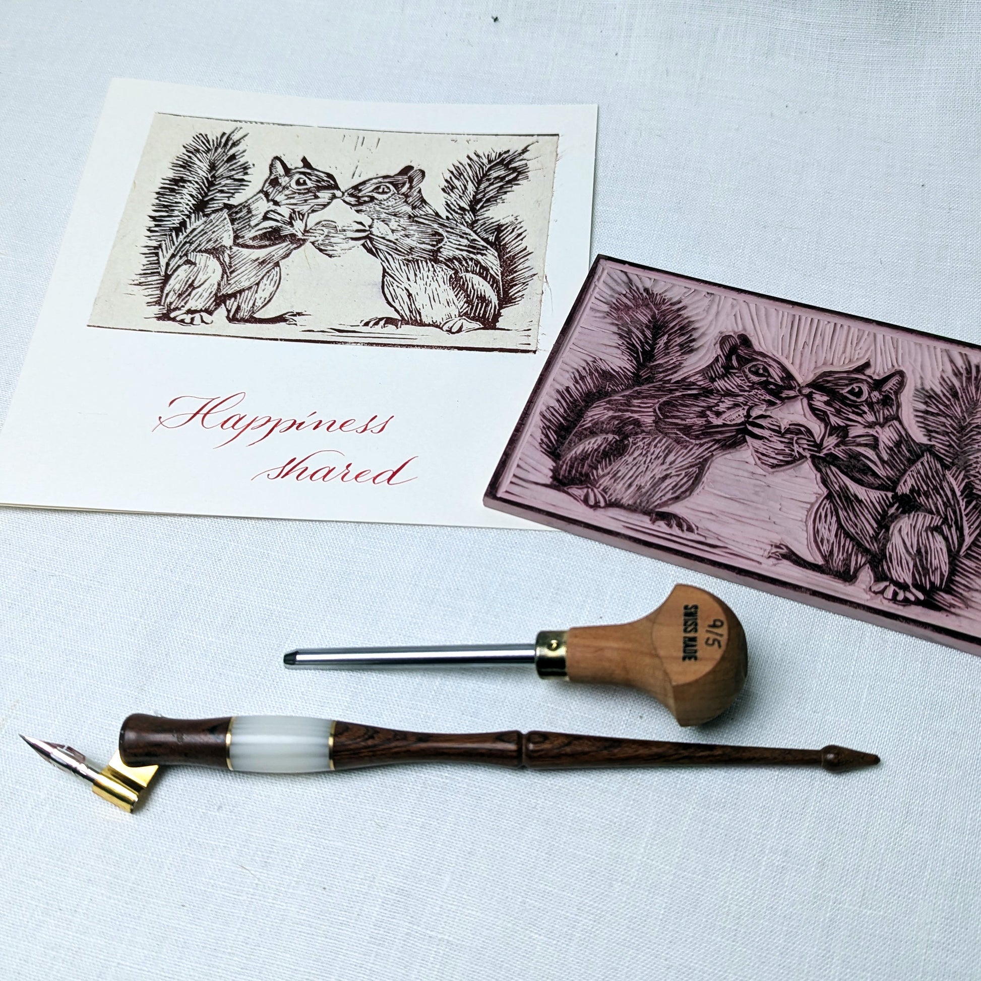Ink pen, ink pad, and printed cards with squirrel illustrations on a light background
