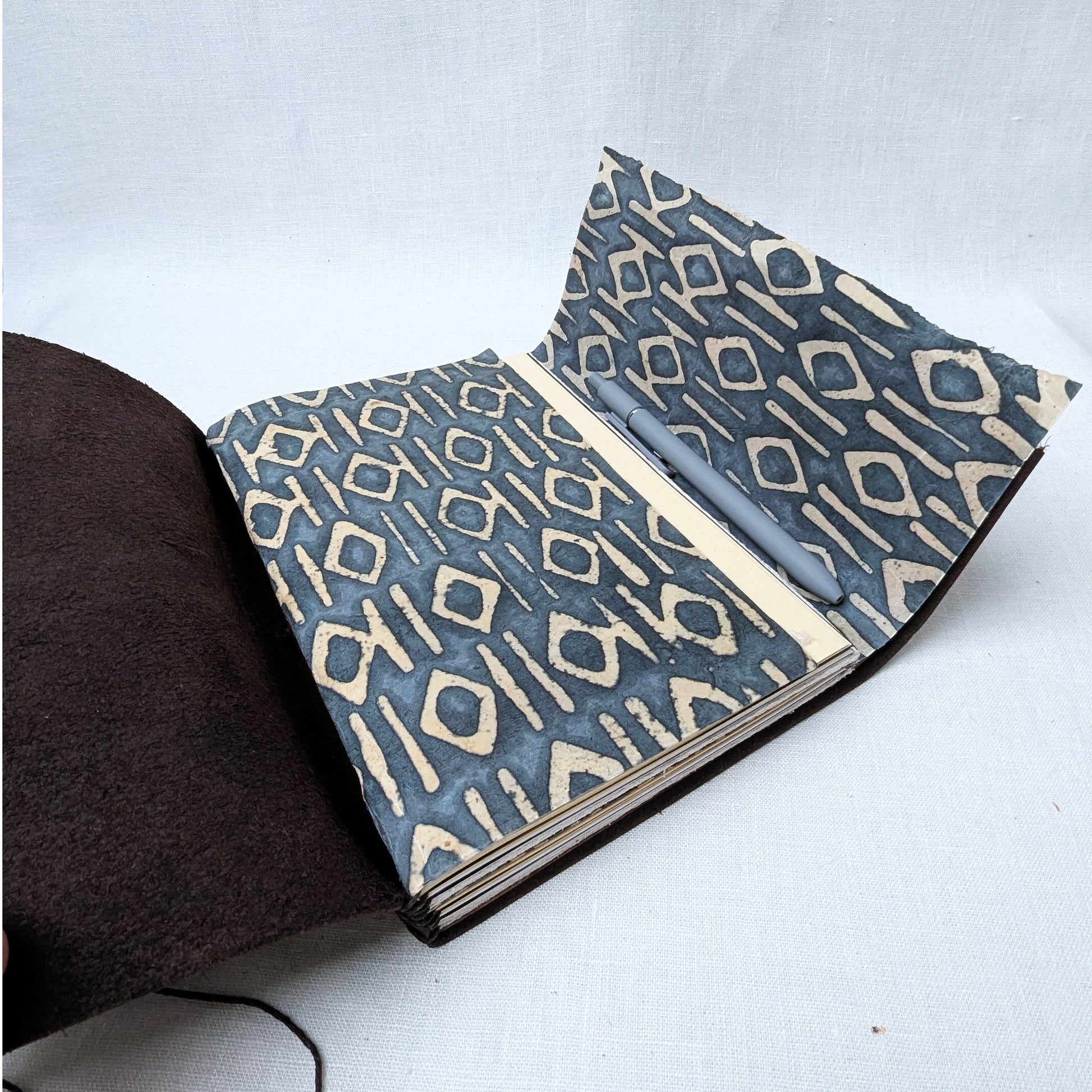 Open book with blue and beige geometric pattern on a white background