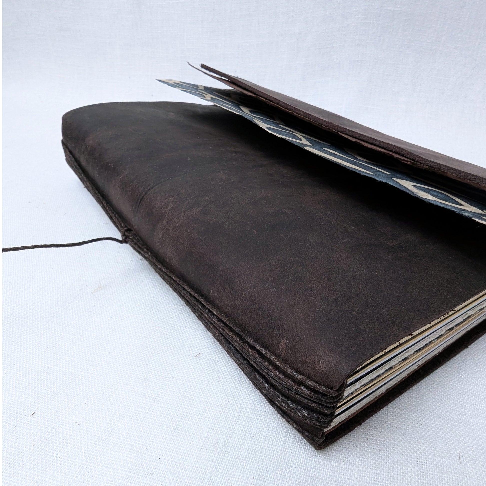 Brown leather notebook with a pen on a white background