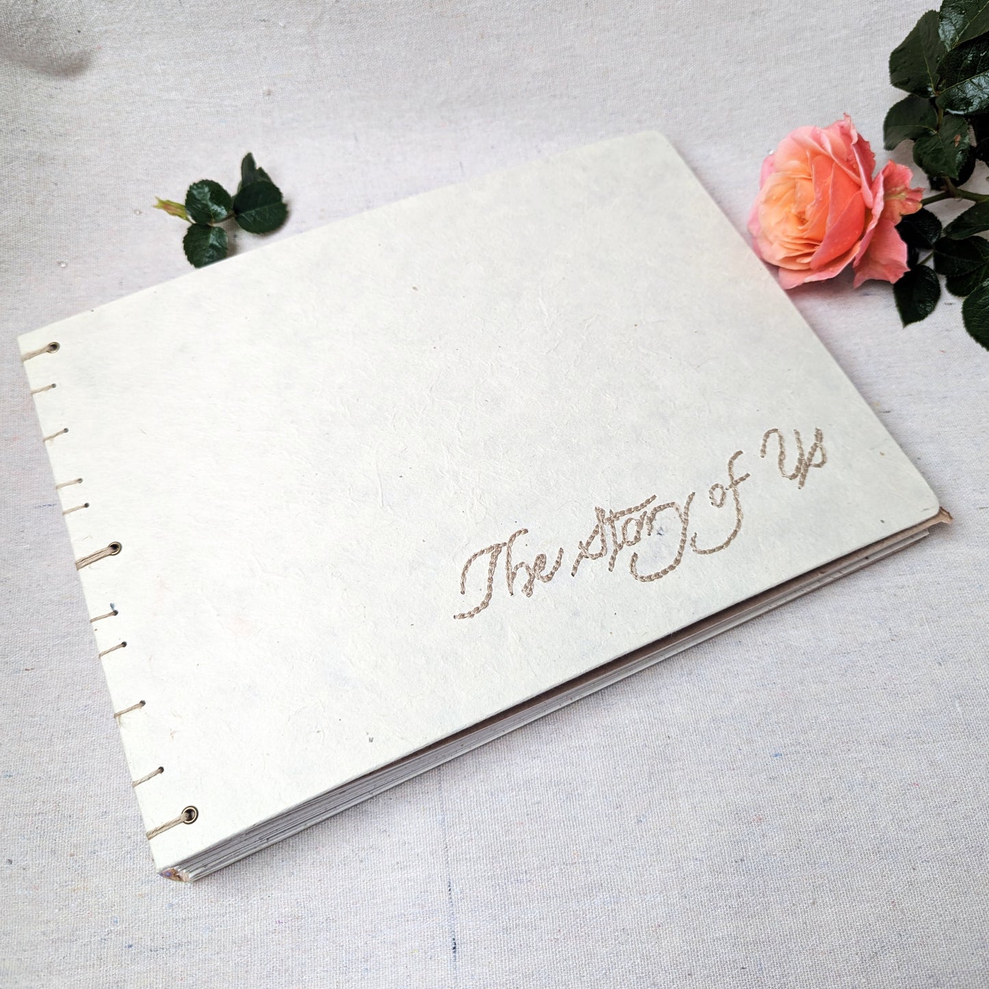 Embroidered photo album with “The Story of Us” on handmade white Lokta paper cover