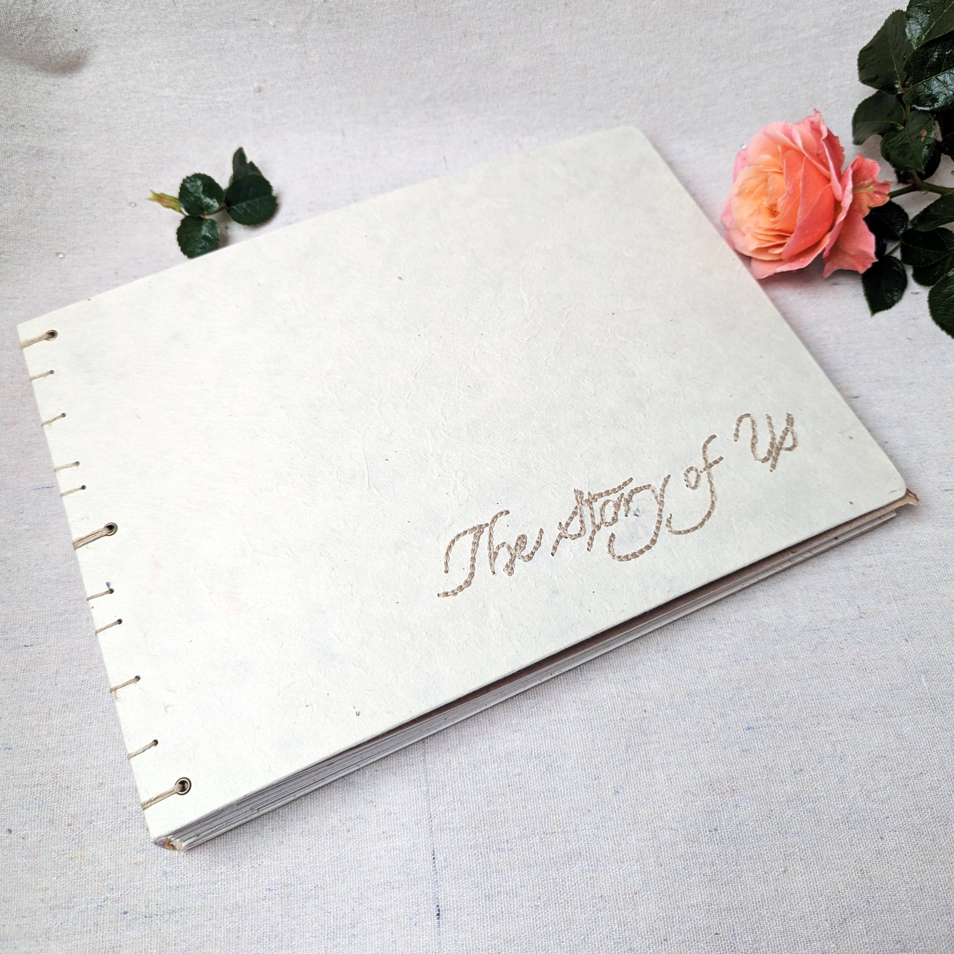 Embroidered photo album with “The Story of Us” on handmade white Lokta paper cover