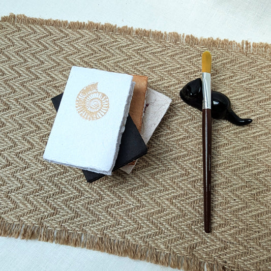 Mini 10x7 cm cotton rag sketchbook with 72 deckled pages, natural paper cover and covered spine. Ideal for pencil, ink and small creative studies.